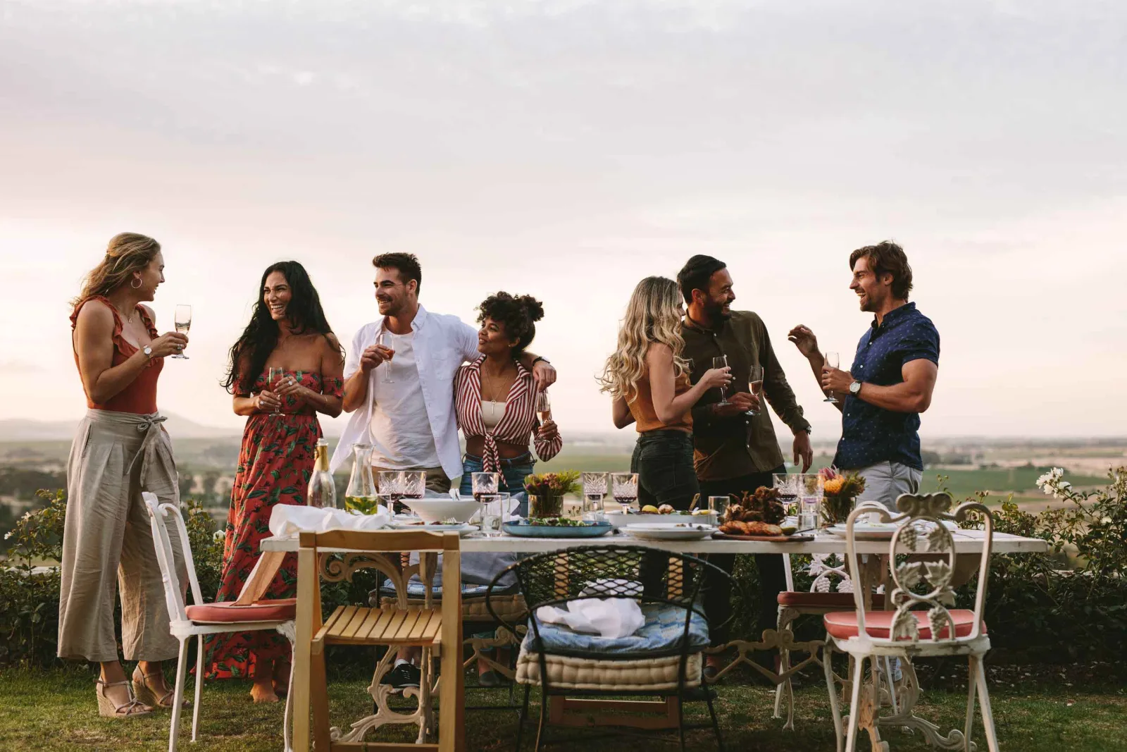 Un grupo de amigos brinda alrededor de una mesa al aire libre