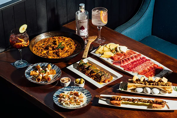 Mesa con arroz, embutidos, quesos y tapas para compartir